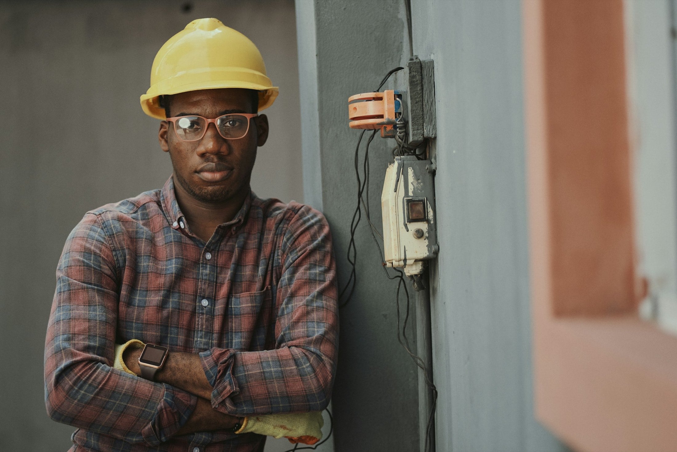 Electrician standing beside a wall panel he just wired