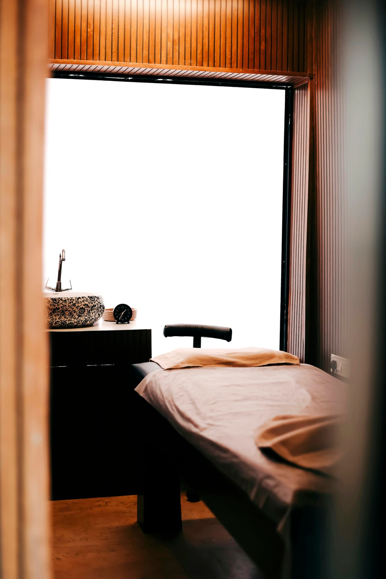 A quiet treatment room with a made-up table, ready for a facial