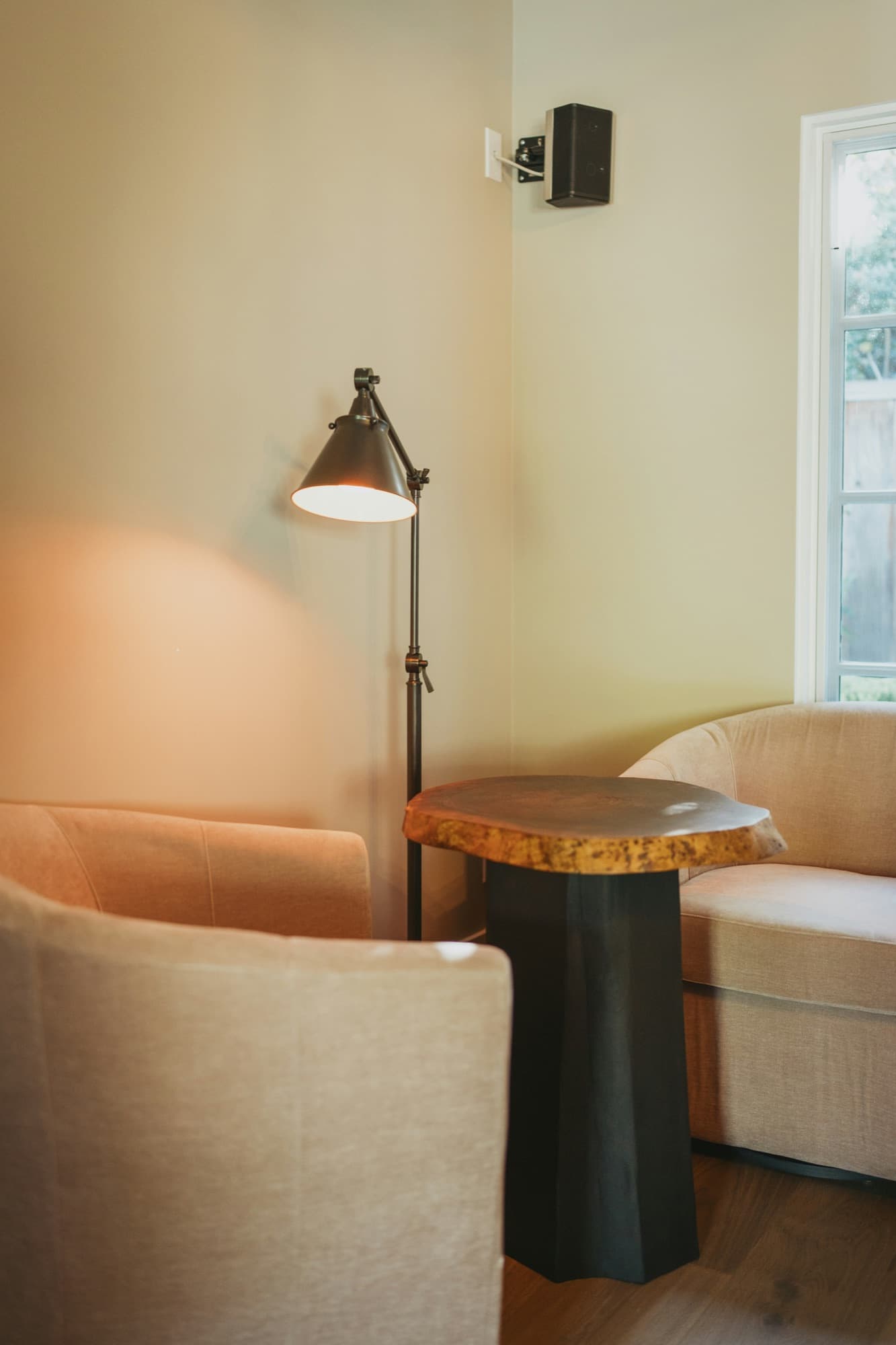 A quiet seating corner with cream armchairs and a warm lamp